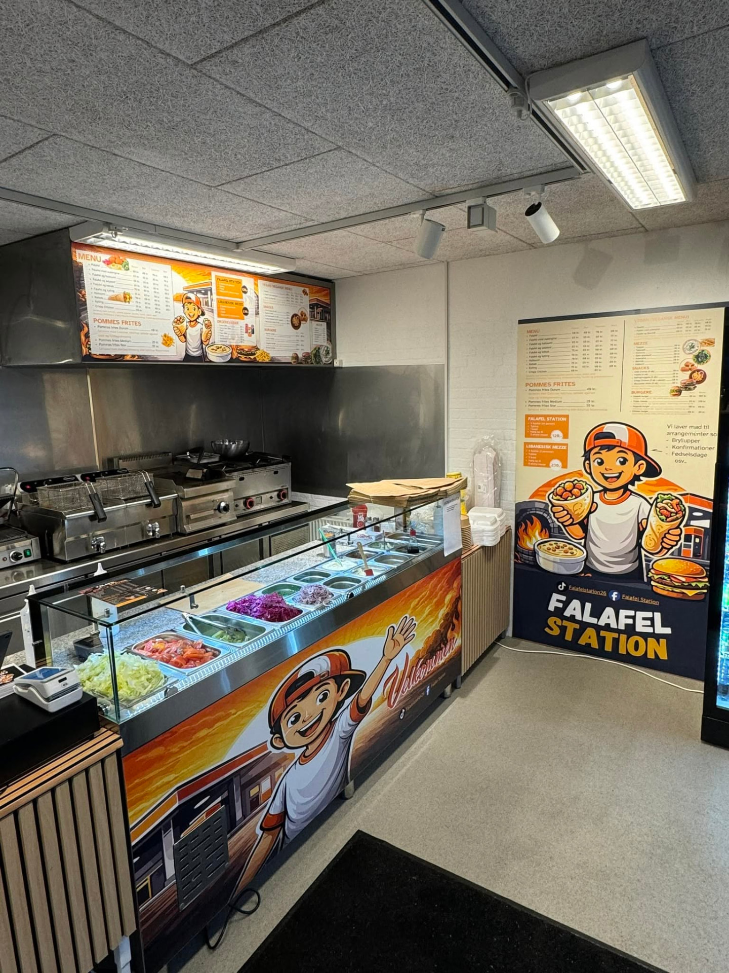 Disken med friske grøntsager og tilbehør i Falafel Station
